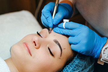Close-up of yelash extension procedure in beauty salon. Woman eye with long eyelashes.