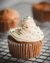 Banana Chocolate Muffin Isolated- topped with buttercream frosting and some colorful sprinkles