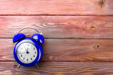 blue alarm clock on wooden boards