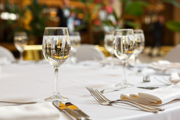 Empty glasses and white napkins are installed in the restaurant on the table.
