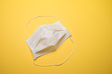 Hygienic face mask isolated over yellow background. Virus outbreak prevention concept.