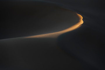 Abstract desert sand dunes with deep shadows and early morning light. - obrazy, fototapety, plakaty