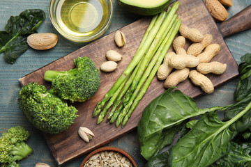 Different products rich in vitamin E on blue wooden table, flat lay