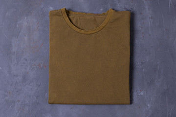 Blank khaki Tshirt on grey concrete background. Mock up for branding t-shirt. 
