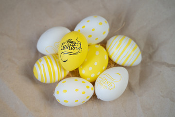 Easter eggs colored  yellow white decorated on crumpled craft paper background. Happy Easter card with copy space for text. Minimal eco easter style.