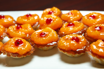 Tartlets with berry filling on a white platter