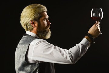 Bartender at bar. experienced sommelier taste wine. barman tasting red wine at degustation. male sommelier appreciating drink. glass of red wine. Bartender at wine cellar with exquisite drink