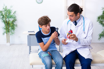 Young male doctor examining boy in the clinic