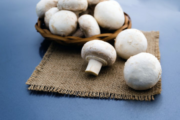 A lot of porcini mushrooms in a wicker plate on a napkin.