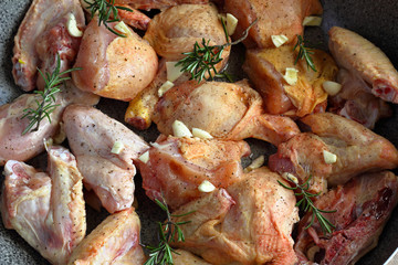 Carne di pollo cruda con aglio pepe e rosmarino pronta per essere cucinata.