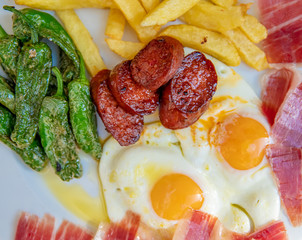 egg with sausage, french fries and vegetable garnish