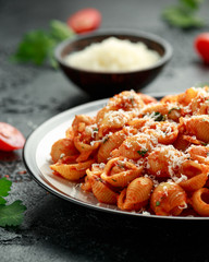 Conchiglie rigate pasta with chickpeas in tomato sauce with parmesan cheese. Healthy vegan food.