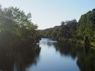 Fototapeta premium Lake and forest illuminated by the sunrise on the road to Santiago de Compostela, Camino de Santiago, Way of St. James, Journey from Vairao 〜 Barcelos, Portuguese way, Portugal