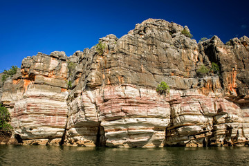 Western Australia – rocky eroded cliffs with trees and shrubs at a large river