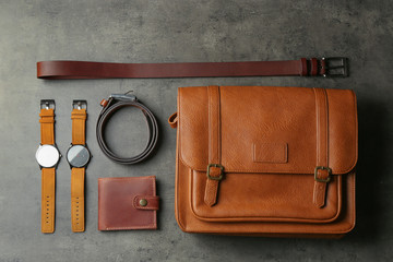 Flat lay composition with leather bag and accessories on grey stone table