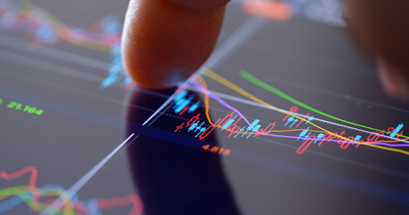 Finger touch on screen with stock market data