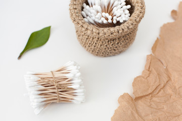 Wooden bamboo and cotton ear buds in a jute basket, ecological life. close-up