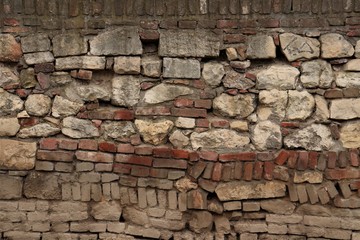 Wall of bricks and stones of different sizes and colors.
