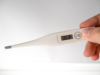 Hand hold digital thermometer  display body temperature.