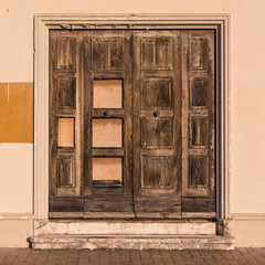 An old door on a derelict and abandoned building in Senigallia, Italy