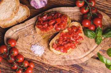 Italian bruschetta, toasted bred with fresh tomato and basil on woody vintage table