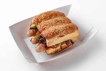 Huge hot dog burger with sausages from minced meat vegetables and herbs. For take away or food delivery isolated on a white background.