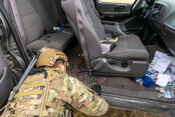 A U.S. Army soldier searches a vehicle for improvised explosive devices