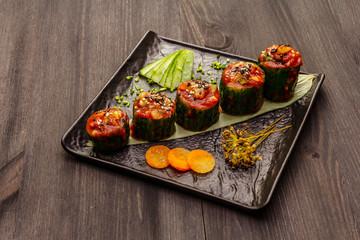 Korean style stuffed cucumbers. Kojori kimchi spicy snack. Fermented and marinated vegetables. Wooden background