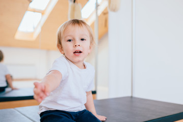 White T-shirt on a cute little smiling boy, on white background. Positive emotions hugging head little child.