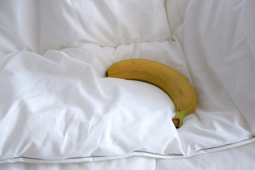 banana on the bed linen. The white texture. Minimalism. Coziness.