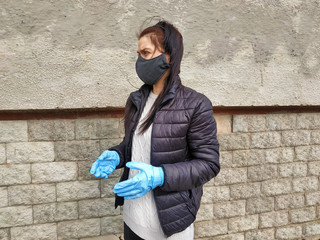 portrait of a girl in profile in a fabric mask sewn handmade Portrait of a girl in a mask and medical gloves - protection against germs and viruses during the coronavirus pandemic.