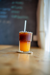 Ice coffee, americano coffee with orange in cafe.