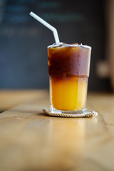 Ice coffee, americano coffee with orange in cafe.
