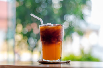 Ice coffee, americano coffee with orange in cafe.
