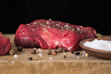 Close-up raw beef and spices salt and pepper seasoning on cutting board