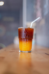Ice coffee, americano coffee with orange in cafe.