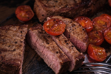 Sliced beef steak with tomato. Close-up grilled meat