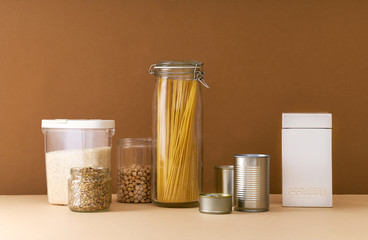 Food staples and toilet paper prepared to survive Coronavirus COVID 19 pandemic at the time of cuarentine and home isolation. Groceries, cans and toilet paper on beige background