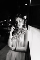 a young girl in a summer dress walks around the city at night