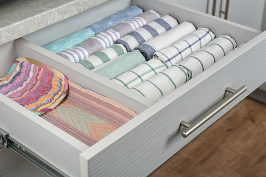 Open drawer with folded towels. Order in kitchen