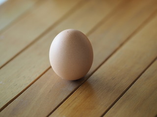 Fresh egg on brown wooden desk
