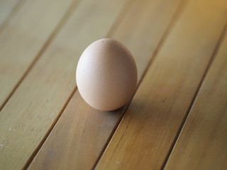 Fresh egg on brown wooden desk