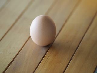 Fresh egg on brown wooden desk