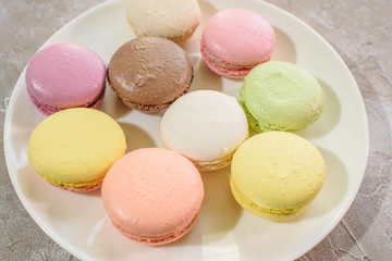 Colored macarons on a plate close-up. Delicious french food.