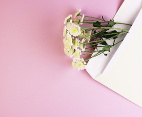 envelope with a bouquet of daisies on a pink background