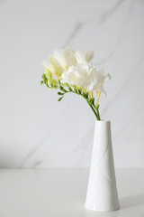 Beautiful bouquet with spring freesia flowers on white table