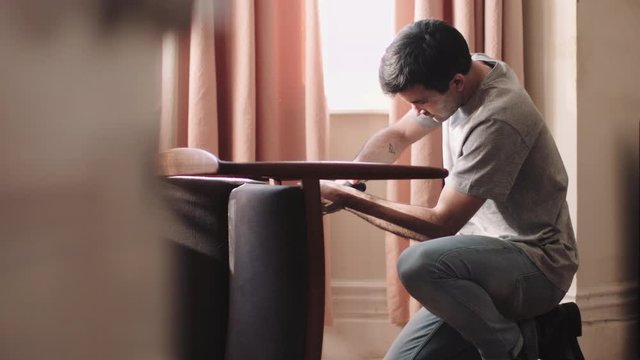 Adult man DIY at home fixing chair