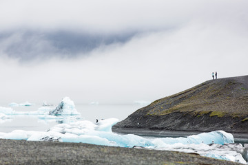 People looking at iceberg and glacier landscape