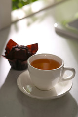 Delicious tea and cupcake on sunlit table. Good morning