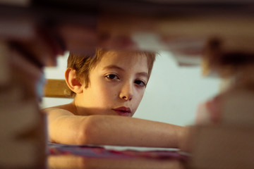 Niño mira detras de libros